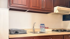 Una cocina con muebles de madera, un lavamanos de acero inoxidable, una estufa a gas y un lavavajillas.