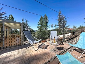 A patio with two lounge chairs, a small table, and a decorative fountain. - La Bergerie de Portes by Interhome (Portes)