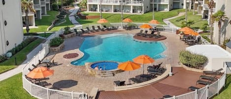 A hotel with a central swimming pool, outdoor seating areas, and a landscaped garden.