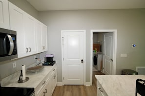 A compact kitchen with a microwave, coffee maker, and a small sink. - Orlando Escape • Near Disney • 5 Bedrooms (Orlando)