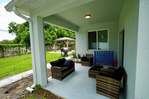 A covered patio area with wicker furniture, a pergola, and a view of a backyard. - Orlando Escape • Near Disney • 5 Bedrooms (Orlando)