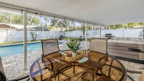 A covered patio with a pool, outdoor furniture, and a grill area. - Pool Oasis - Family Getaway - Hot Tub - Pets OK (Port Orange)