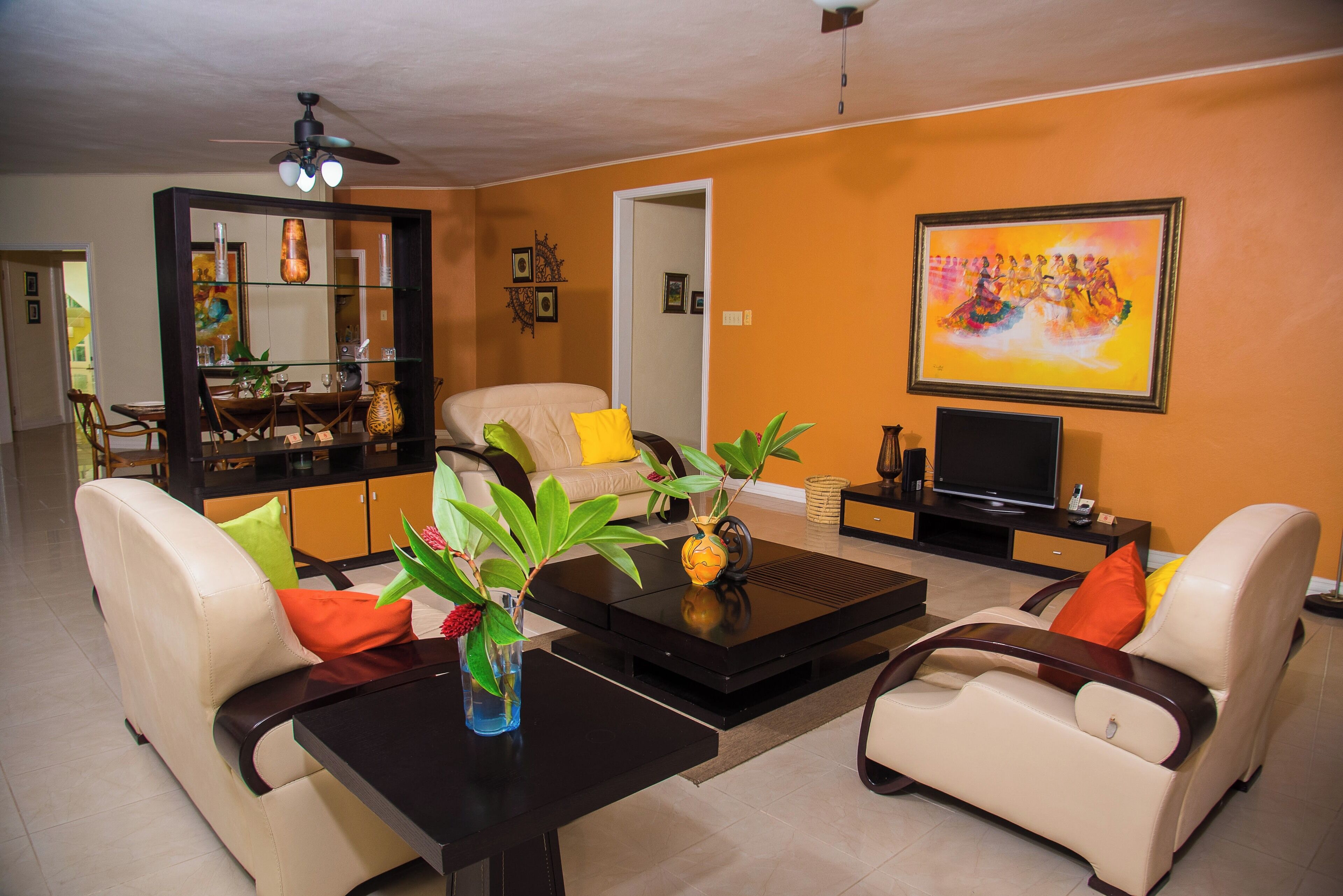 A living room with a sofa, coffee table, TV, and a painting on the wall.