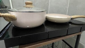 En köksbänk med en vit kastrull och en vit stekpanna.