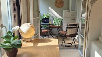 Une chambre moderne avec un plancher en bois, un bureau sur lequel se trouve un globe terrestre, une chaise et une table.