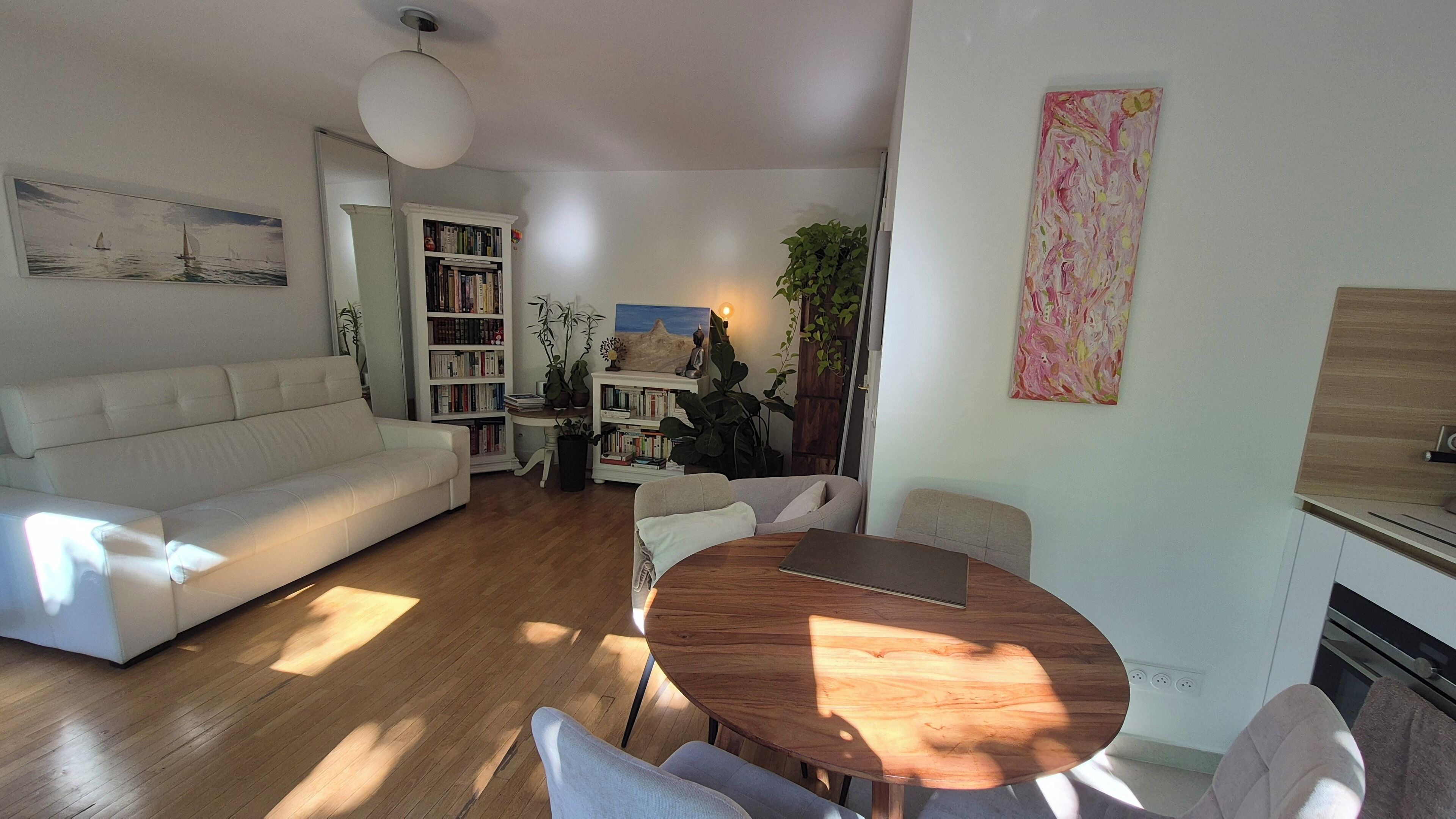 A living room with a sofa, a wooden coffee table, and a bookshelf.