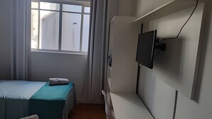 A bedroom with a bed, a window, and a mounted television. - Quarto Triplo Augusta Paulista Frei Cane (São Paulo)
