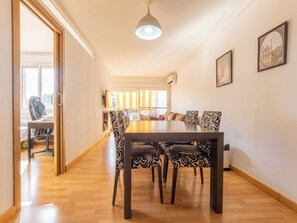 A dining area with a wooden table and patterned chairs, a ceiling light, and a view through a window. - Faro Grande Salou by Interhome (Salou)