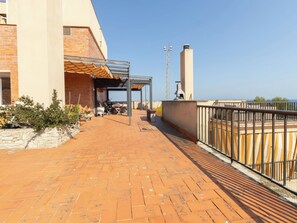 A rooftop patio with a covered seating area, a barbecue grill, and a view of the sea. - Faro Grande Salou by Interhome (Salou)