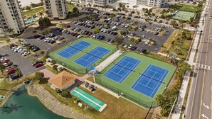 Ein mehrgeschossiges Parkhaus, Tennisplätze und ein kleiner Poolbereich.
