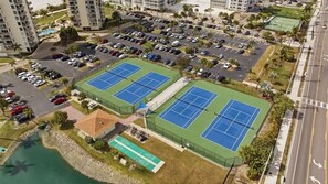 A multi-story parking structure, tennis courts, and a small pool area. - Estero Beach & Tennis - Where Every Stay Comes with a WATERFRONT VIEW 405C (Fort Myers Beach)