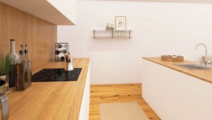 Una cuina moderna amb taulells de fusta, forlla integrada i una petita illa amb un rentaplat.