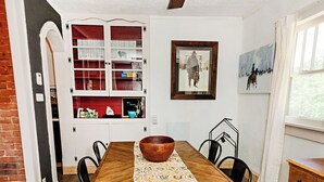 A dining area with a wooden table, chairs, a ceiling fan, and a decorative rug. - Little House on Taylor - 2 Bedroom Cottage in Walkable Downtown Location (Craig)