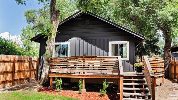 A wooden cabin with a porch and a small deck. - Little House on Taylor - 2 Bedroom Cottage in Walkable Downtown Location (Craig)