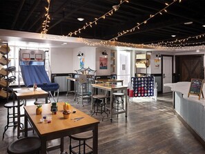 A cozy indoor space with tables, chairs, and string lights. There are artworks on the walls and a counter with a chalkboard menu. - 1 Bedroom Villa at Marriott MountainSide Resort (Park City)
