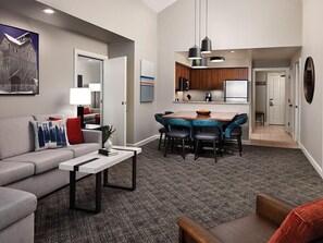 A modern living room with a sofa, coffee table, and a dining area with chairs and a table. - 1 Bedroom Villa at Marriott MountainSide Resort (Park City)