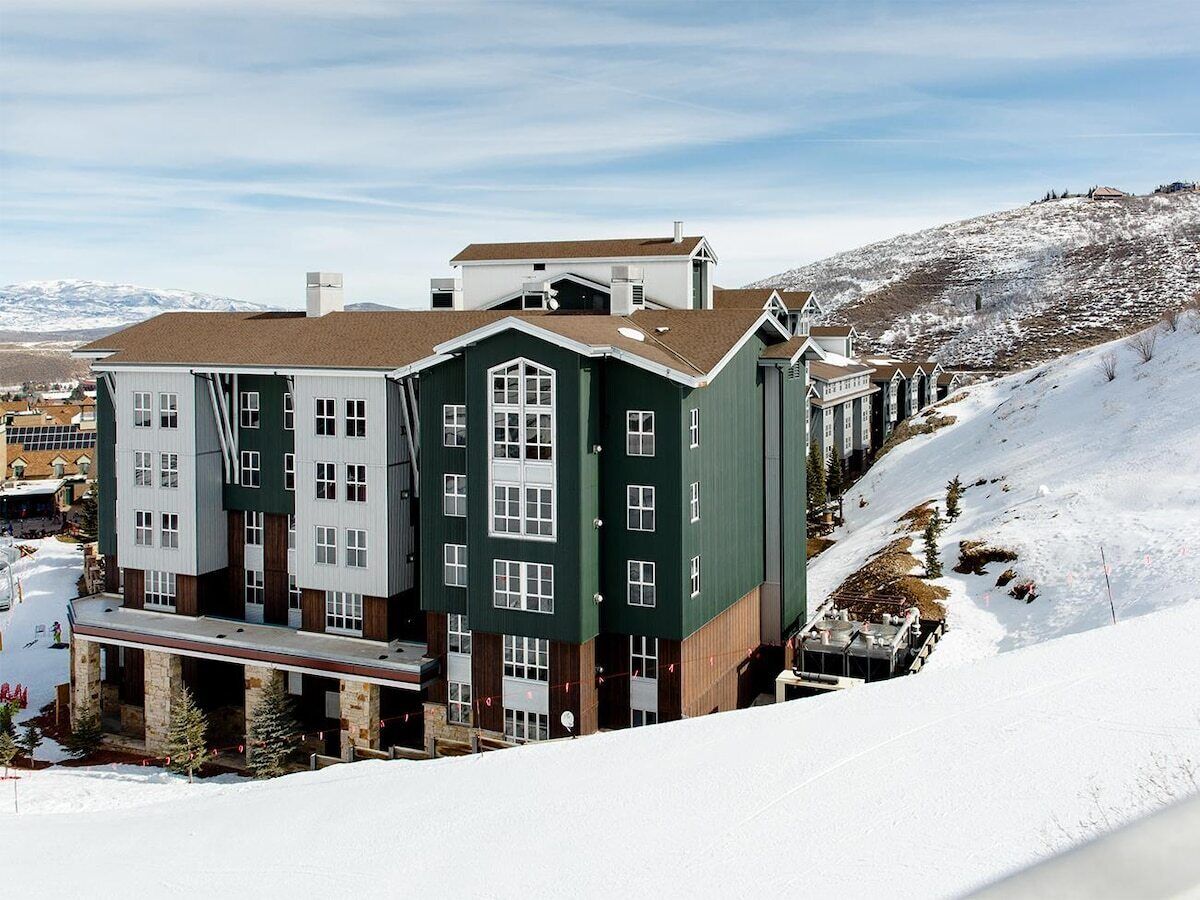 Un edificio de varios pisos con un paisaje nevado al fondo.