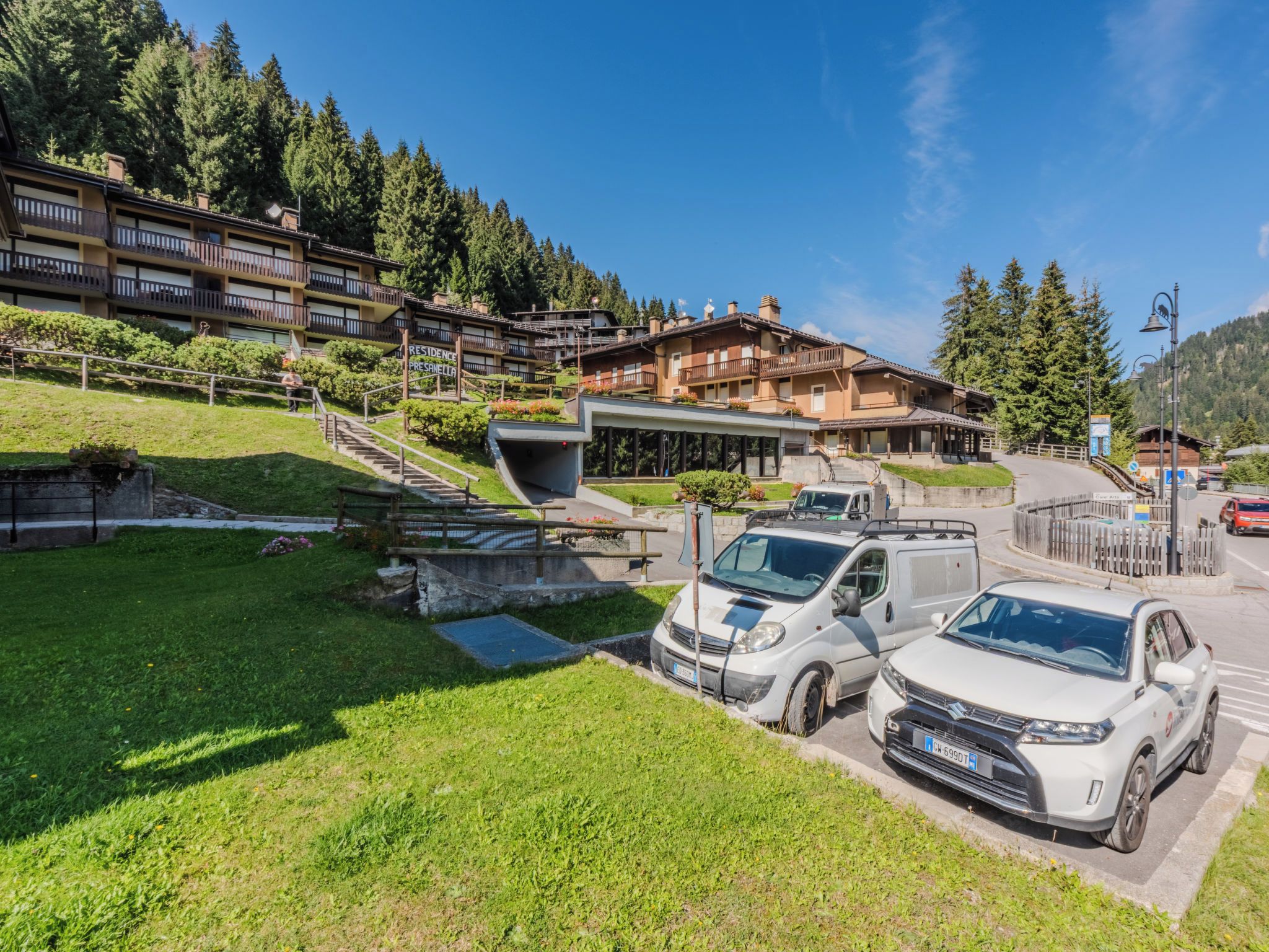 Un hotel de diseño moderno, con zona de estacionamiento y vistas al bosque circundante.