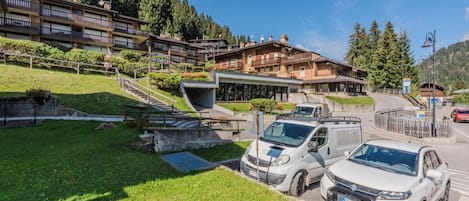 Un hotel de diseño moderno, con zona de estacionamiento y vistas al bosque circundante.