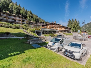 A hotel with a modern design, a parking area, and a view of the surrounding forest. - Presanella by Interhome (Madonna di Campiglio)