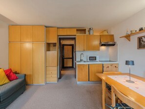 A compact kitchen with wooden cabinets, a microwave, and a sink. - Presanella by Interhome (Madonna di Campiglio)