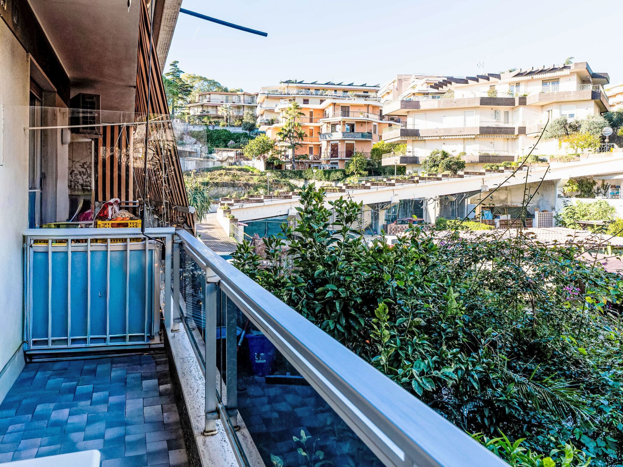 Un balcón con vista a una zona residencial, que incluye casas y un puente.