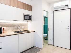 A modern kitchen with a built-in microwave, a stainless steel sink, and a coffee maker. - Casa Letizia by Interhome (Sanremo)