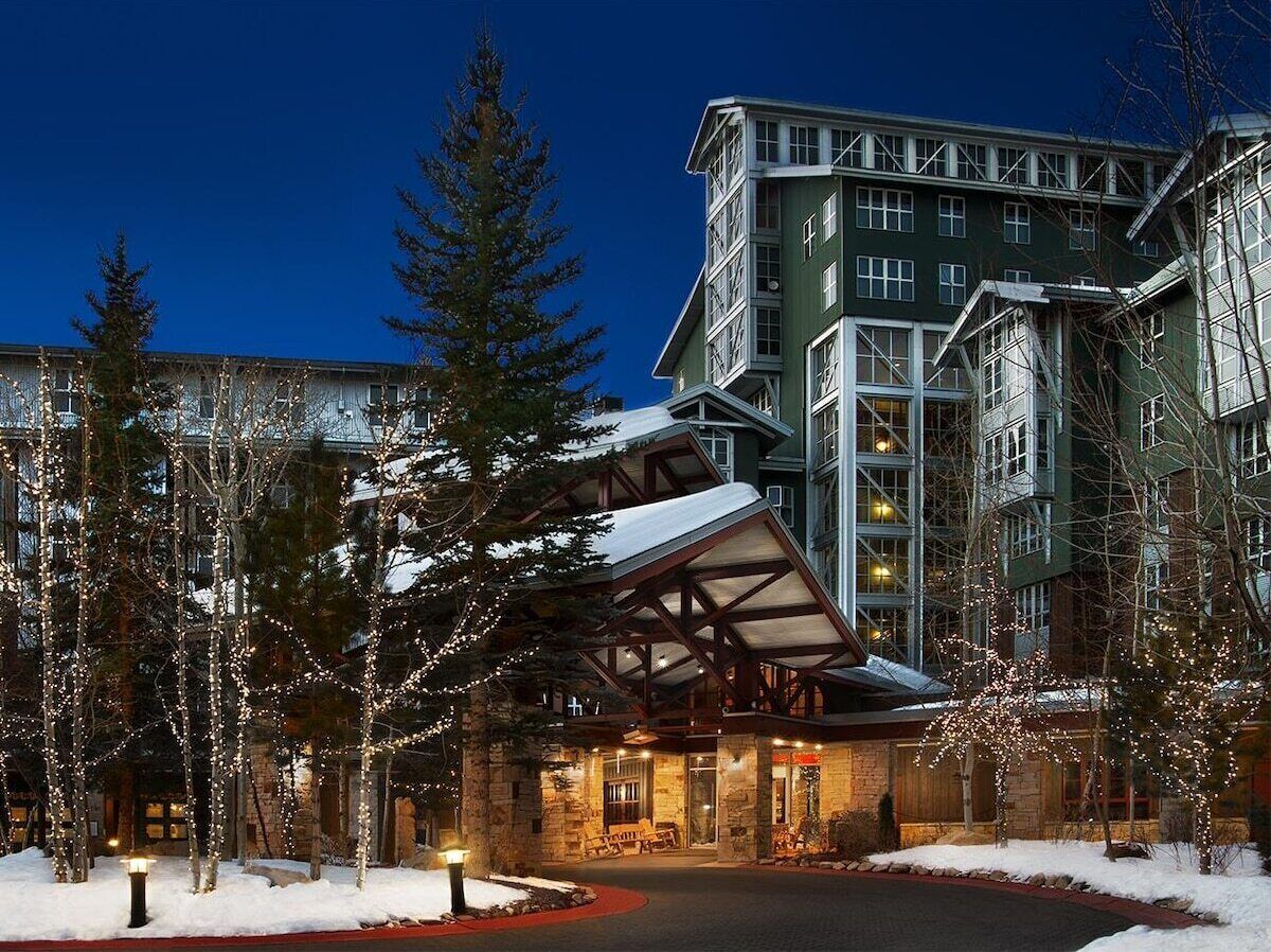 A hotel with a prominent entrance, large windows, and a snow-covered landscape.