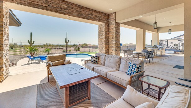 An outdoor patio with a pool, seating area, and a view of the desert landscape. - Apache Junction Vacation Rental Heated Pool, Mountain Views, Pet-Friendly Home (Apache Junction)