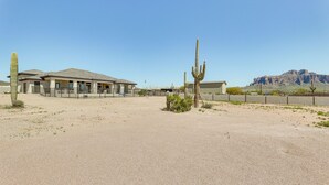 A building with a flat roof and a fenced courtyard. - Apache Junction Vacation Rental Heated Pool, Mountain Views, Pet-Friendly Home (Apache Junction)