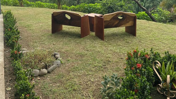 A bench in a garden with a view of a mountainous landscape.