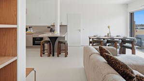 Ein modernes Interieur mit Küche, Essbereich und einer Couch mit Leopardenmuster-Kissen.