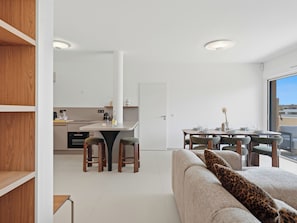 Ein modernes Interieur mit Küche, Essbereich und einer Couch mit Leopardenmuster-Kissen.
