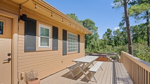 Una terraza de madera con una mesa de picnic y un jacuzzi.