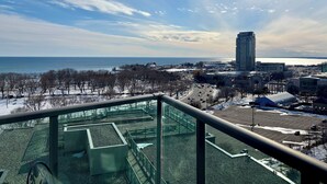 A cityscape with a view of the sea, buildings, and a parking area. - Sundrenched 2 BDRM waterfront gem with lake view near CNE, BMO Field (Toronto)