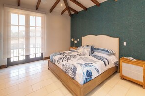 A bedroom with a large bed, a wooden headboard, a bedside table, and a window with blinds. - 4BR Luxury Villa, Private Pool + Terrace in Las Catalinas (Guanacaste Province)