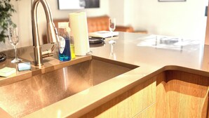 A kitchen with a modern design, featuring a stainless steel sink, wooden cabinets, and a ceiling fan. - Cozy 1-bedroom apartment in serene Atlanta with fitness room (Atlanta)