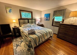 A bedroom with a bed, a dresser, a chair, two bedside tables with lamps, and artwork on the walls. - Enjoy the best of Cape Cod. Perfect. Private.Parking. Pets. Available Sept 1 (Dennis)