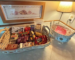 Ein Korb mit verschiedenen Snacks und ein Korbinnenleben mit einem rosa Gegenstand.