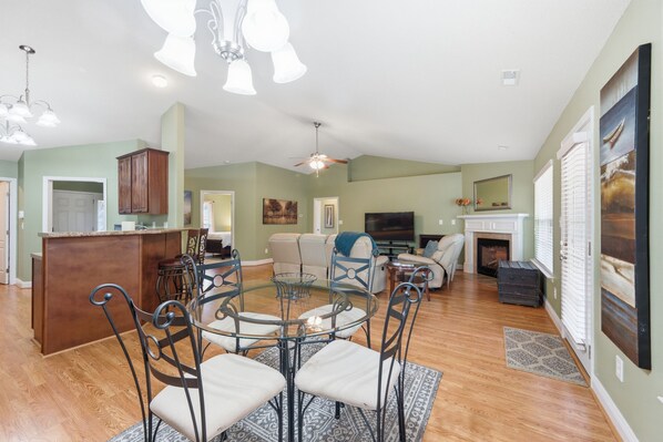 A spacious living area with a dining table, chairs, a fireplace, and a television. - Welcome to The Amsterdam Place. (Madison)