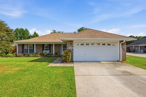 A single-story house with a garage, a front lawn, and a brick facade. - Welcome to The Amsterdam Place. (Madison)