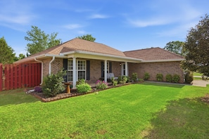 A single-story brick house with a front porch, a red fence, and a well-maintained lawn. - Welcome to The Amsterdam Place. (Madison)