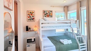 A bunk bed room with a desk, a microwave, and artwork on the walls. - Cozy Ensuite Room Near Mt. Rainier & Seattle (Bonney Lake)