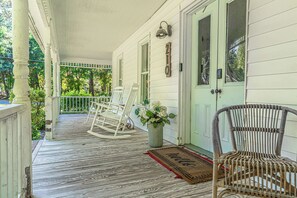 A porch with two rocking chairs, a potted plant, and a doormat. - NEW! Downtown Charmer- Steps to downtown SoPines! (Southern Pines)