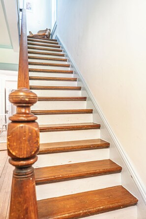A wooden staircase with white risers and a wooden handrail. - NEW! Downtown Charmer- Steps to downtown SoPines! (Southern Pines)