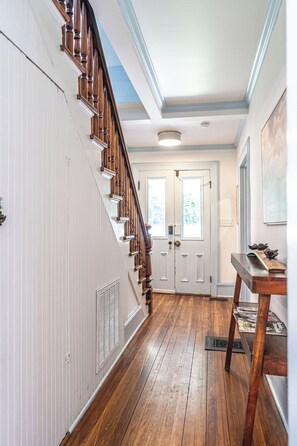 A wooden staircase leading to a door with a window, a white wall, and a ceiling light. - NEW! Downtown Charmer- Steps to downtown SoPines! (Southern Pines)