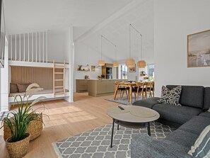 Ein zeitgemäßer Wohnraum mit Schlafgalerie, Essbereich und Küche.