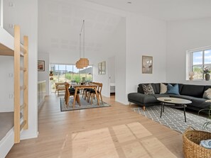A spacious living area with a dining table, sofa, and a view of the outdoors. - "Karoliina" - 500m from the sea by Interhome (Løkken)