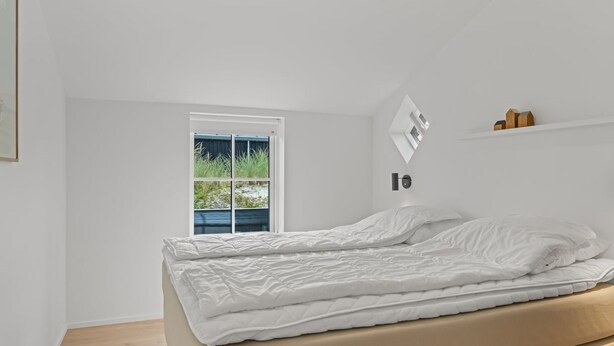 Una camera da letto con un letto, una finestra e una mensola a parete.