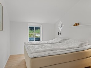 A bedroom with a bed, a window, and a wall-mounted shelf. - "Karoliina" - 500m from the sea by Interhome (Løkken)